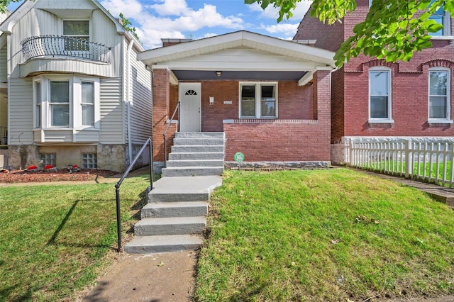 view of front of home featuring a balcony and a front yard