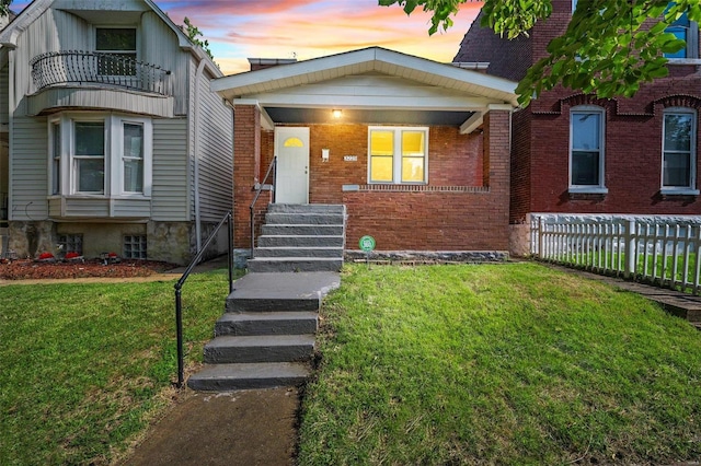 view of front facade with a balcony and a yard