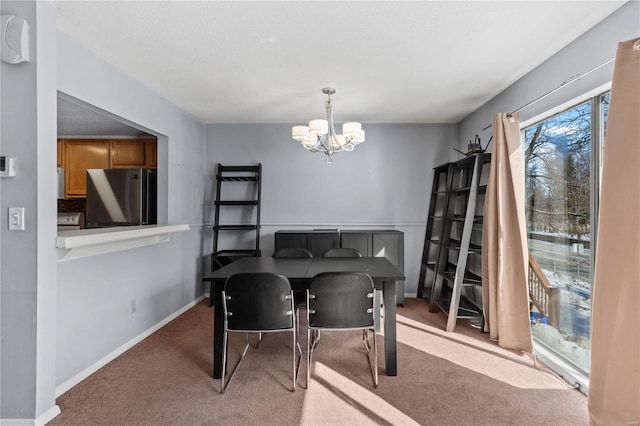 carpeted dining room featuring baseboards and an inviting chandelier