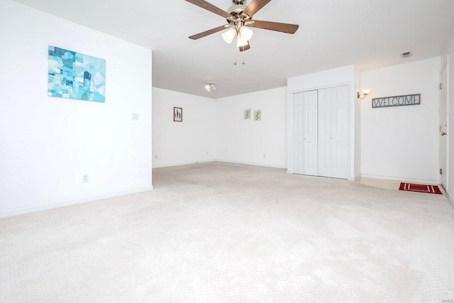 unfurnished room with ceiling fan and light carpet