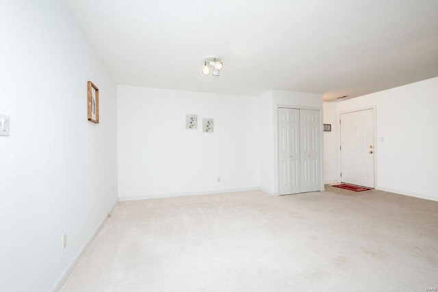 unfurnished room featuring light colored carpet