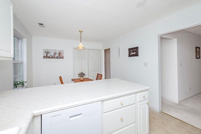 kitchen with pendant lighting, light colored carpet, white dishwasher, and white cabinets