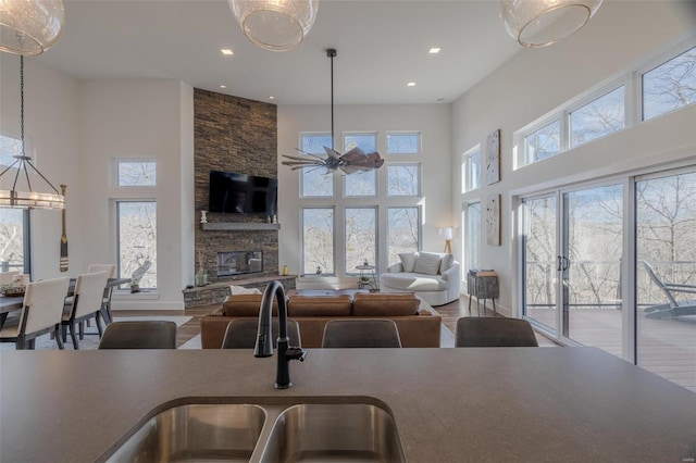 kitchen featuring hardwood / wood-style floors, decorative light fixtures, sink, and a stone fireplace