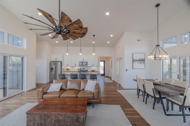 living room featuring a notable chandelier, hardwood / wood-style flooring, and a high ceiling