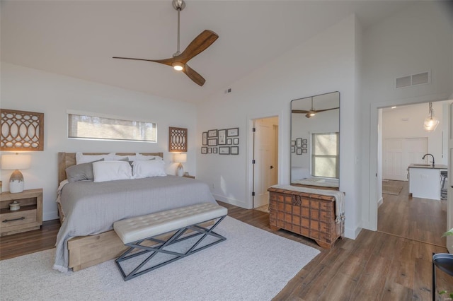 bedroom with ceiling fan, high vaulted ceiling, sink, and dark hardwood / wood-style flooring