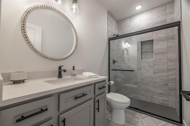 bathroom with vanity, an enclosed shower, and toilet