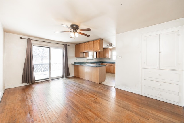 kitchen featuring ceiling fan, kitchen peninsula, and light hardwood / wood-style flooring