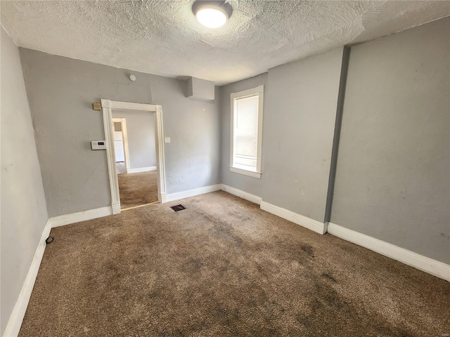 carpeted spare room with a textured ceiling