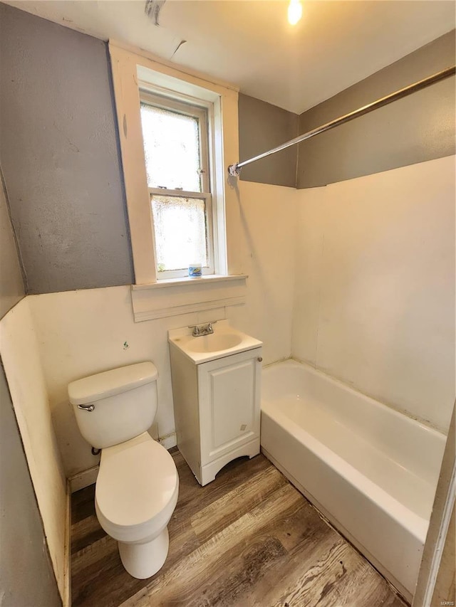 full bathroom featuring hardwood / wood-style flooring, vanity, shower / bath combination, and toilet