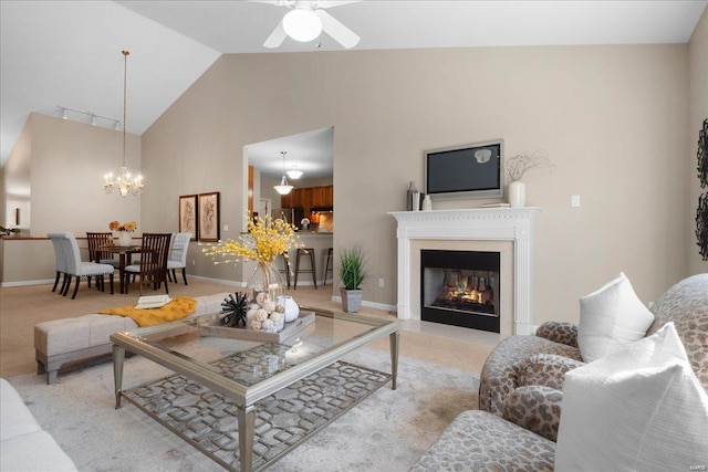 carpeted living room with ceiling fan with notable chandelier and high vaulted ceiling