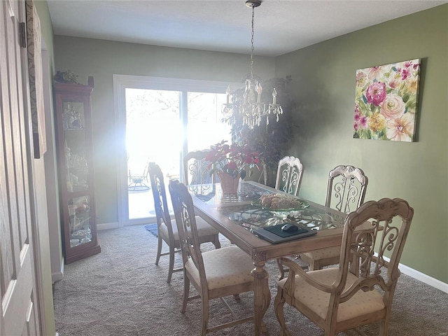 carpeted dining room with an inviting chandelier