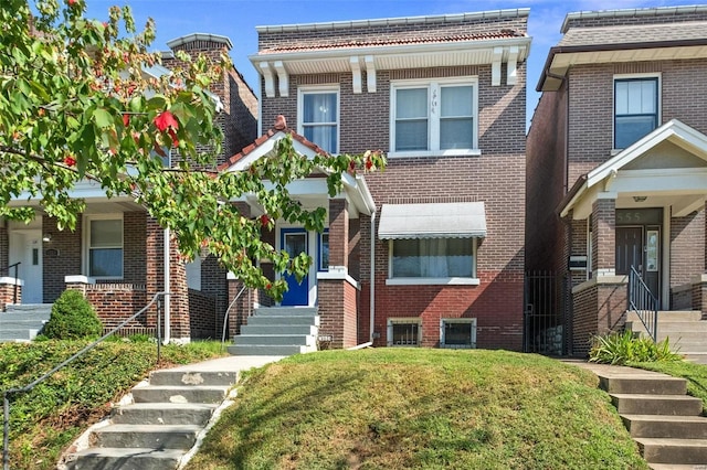 view of front facade with a front lawn and brick siding