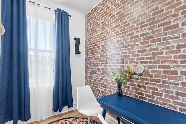 office area featuring brick wall and wood finished floors