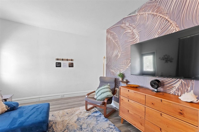 living area featuring baseboards and wood finished floors