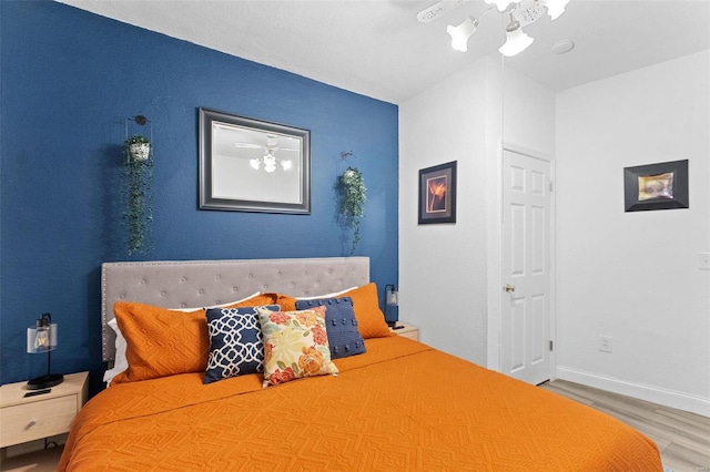 bedroom featuring baseboards and wood finished floors