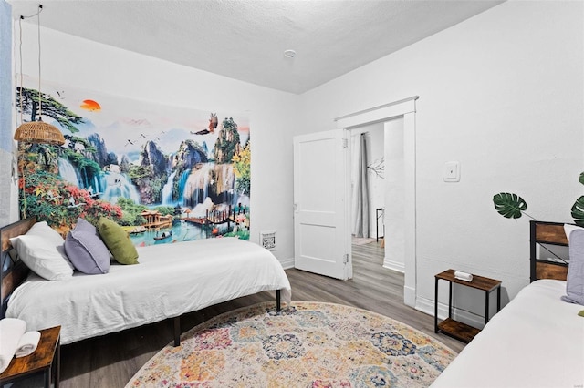 bedroom with dark wood-style floors, a textured ceiling, visible vents, and baseboards