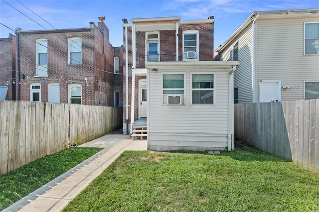 back of house with cooling unit, a fenced backyard, a lawn, and brick siding