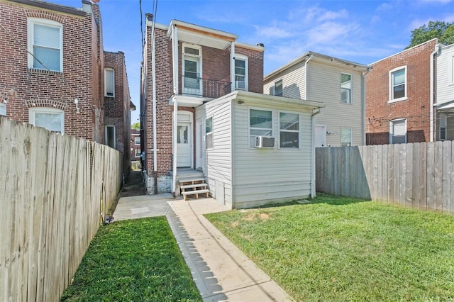 rear view of house with a lawn, cooling unit, and a fenced backyard