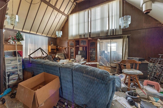 living room featuring high vaulted ceiling and wood walls