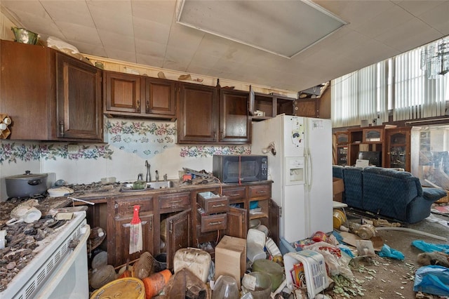 kitchen featuring dark brown cabinetry, sink, and white appliances