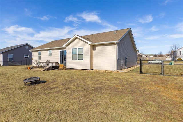 rear view of property with an outdoor fire pit and a yard