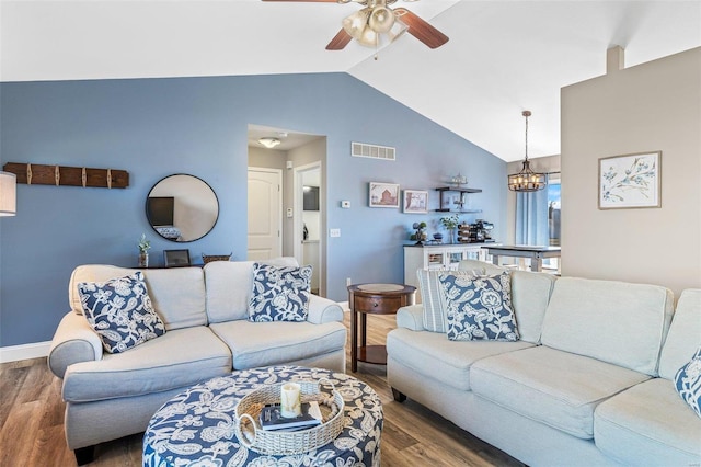 living room with lofted ceiling, ceiling fan with notable chandelier, and dark hardwood / wood-style flooring