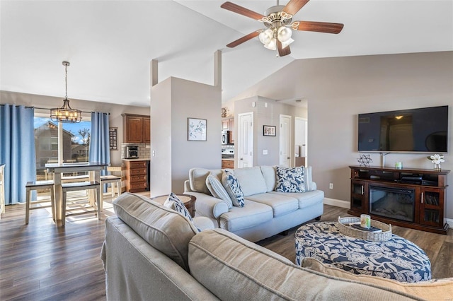 living room with lofted ceiling, ceiling fan with notable chandelier, and dark hardwood / wood-style flooring