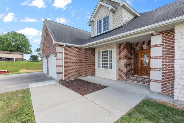 entrance to property featuring a garage and a lawn