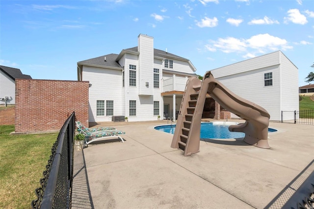 view of pool featuring a patio area, a lawn, and a water slide