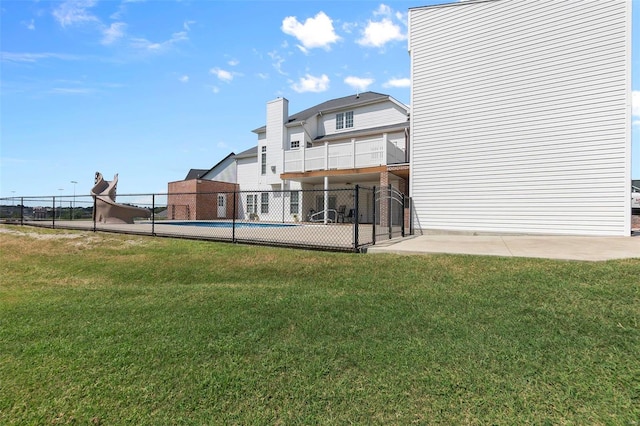 back of property featuring a yard and an empty pool