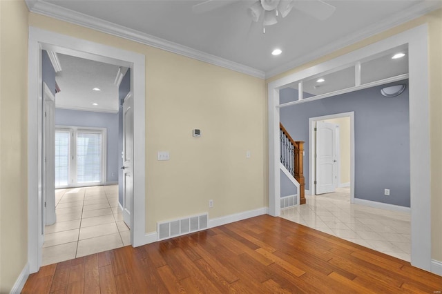 empty room featuring light hardwood / wood-style flooring, ornamental molding, and ceiling fan