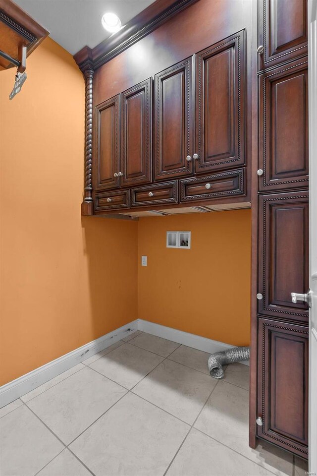 laundry area featuring crown molding, cabinets, hookup for a washing machine, and light tile patterned floors