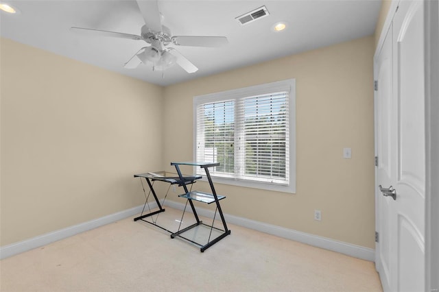 carpeted office space featuring ceiling fan