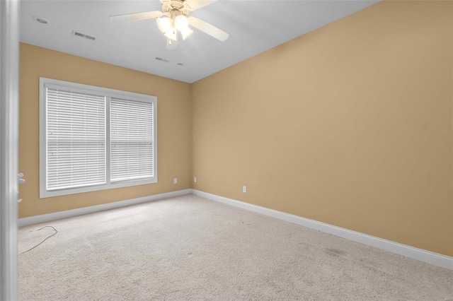 unfurnished room with light colored carpet and ceiling fan