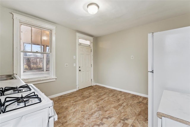 kitchen with white appliances, baseboards, and light countertops