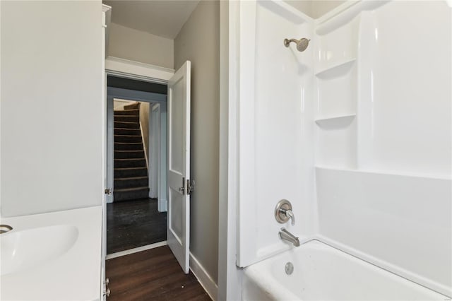 bathroom with baseboards, wood finished floors, and shower / bathing tub combination