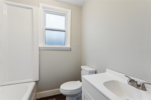 bathroom featuring toilet, a tub, and vanity