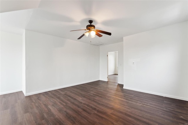 empty room featuring dark wood finished floors, attic access, and baseboards