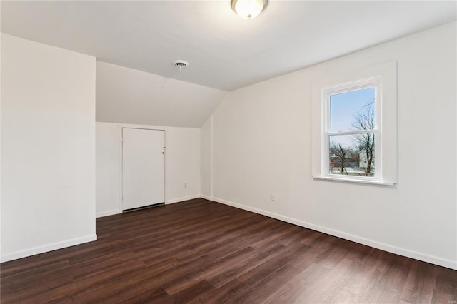 additional living space with lofted ceiling, dark wood-style flooring, and baseboards