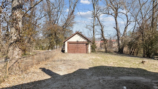 view of yard featuring an outbuilding, driveway, and a detached garage