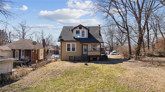 view of front of property with entry steps, a front lawn, a chimney, and stucco siding