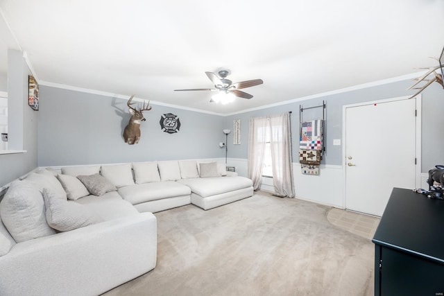 living room with ornamental molding, carpet, and ceiling fan