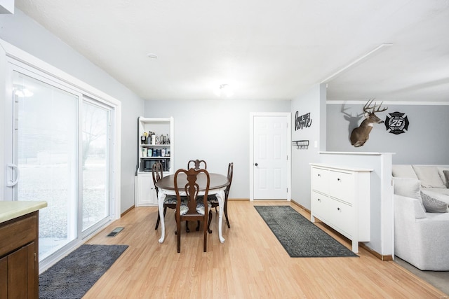 dining space with light hardwood / wood-style floors and a healthy amount of sunlight