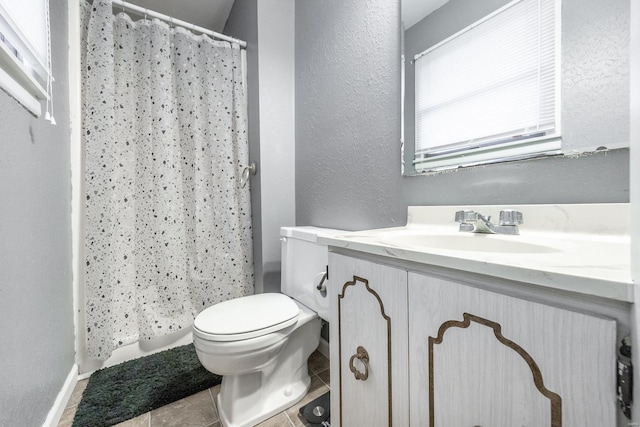 bathroom with vanity, tile patterned floors, toilet, and walk in shower