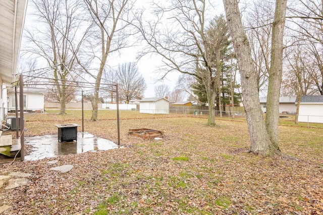 view of yard with central AC and an outdoor fire pit