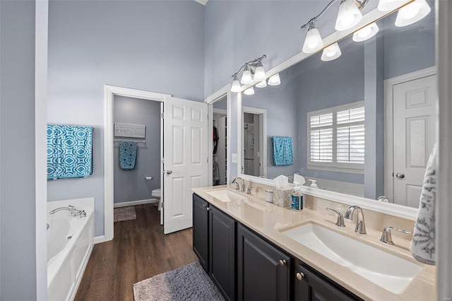 bathroom with vanity, hardwood / wood-style flooring, toilet, and a bathing tub