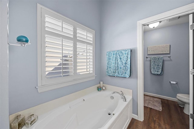 bathroom featuring a bathing tub, wood-type flooring, and toilet