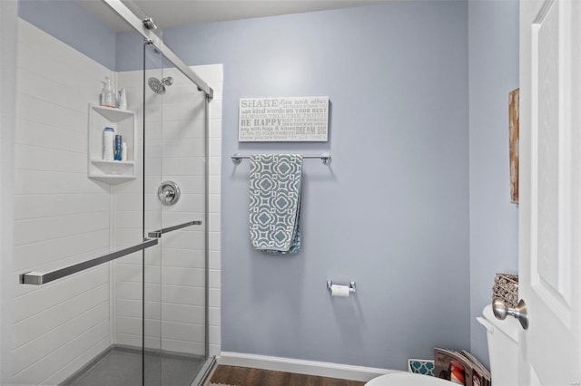 bathroom featuring wood-type flooring, toilet, and an enclosed shower