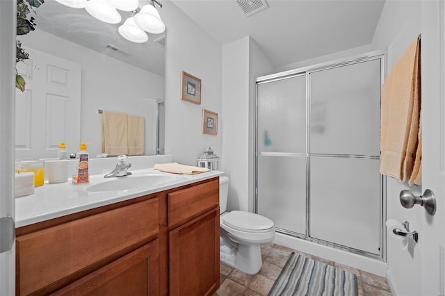 bathroom featuring vanity, a shower with shower door, and toilet