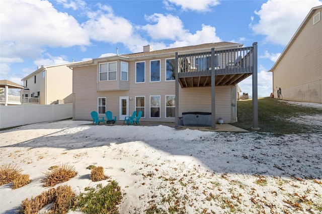 snow covered rear of property with a fire pit